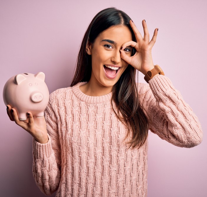 Illustration: Frau mit Sparschwein in der rechten Hand deutet das OK-Zeichen mit der linken Hand