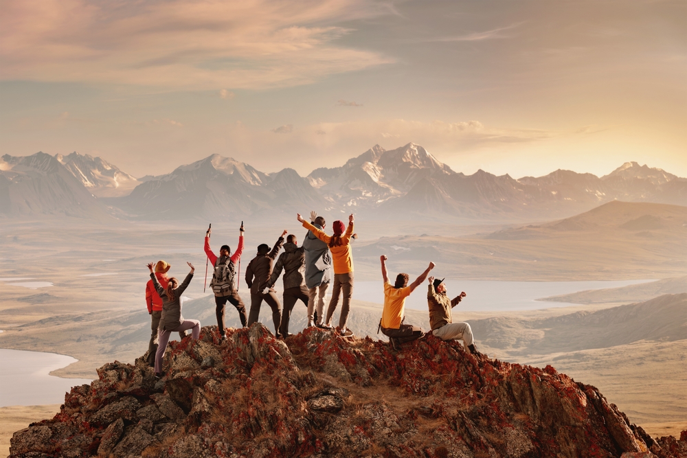 Illustration: Große Gruppe glücklicher Touristen haben Spaß und Gruß Sonnenuntergang auf der Bergspitze.